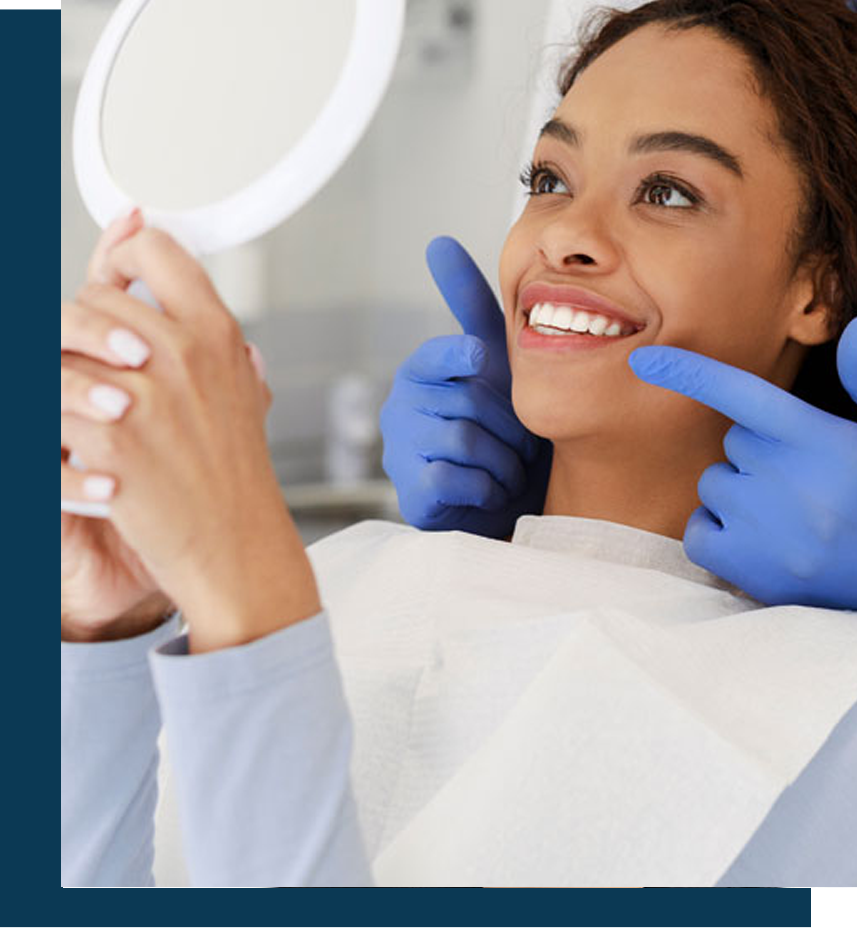 Image of a patient checking her teeth in mirror