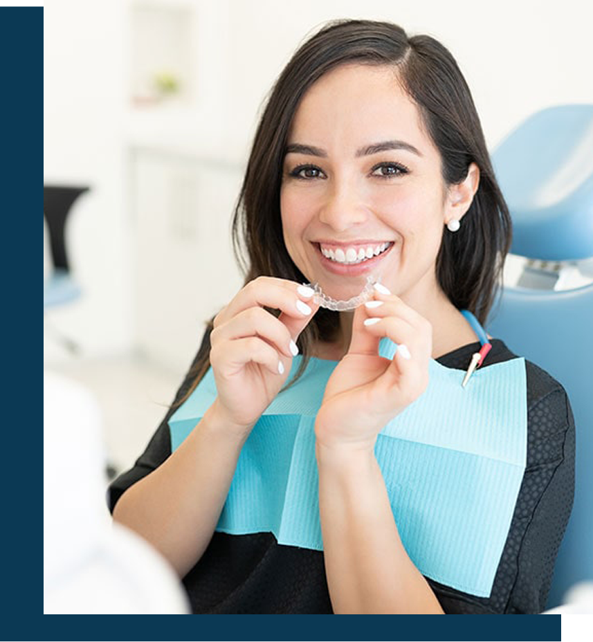 Image of a smiling patient holding trasparant braces